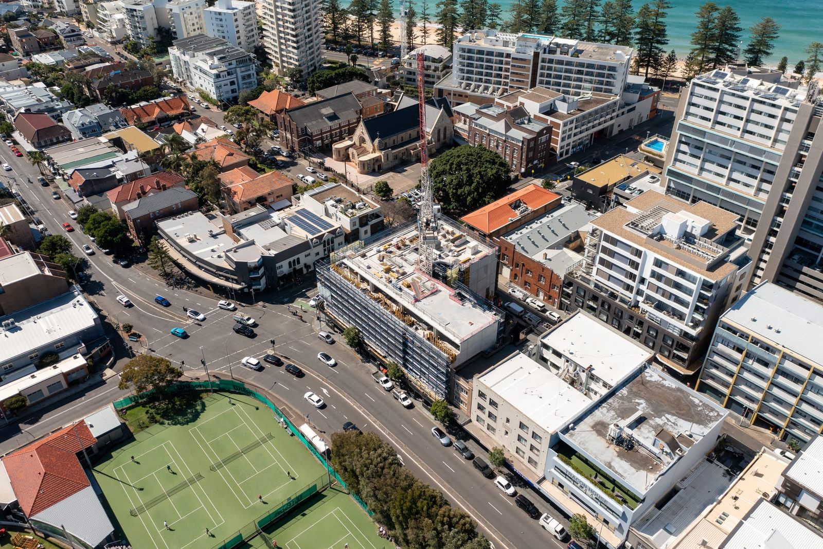 High view over the Manly streets, the scaffolded site among apartment blocks near the tennis courts