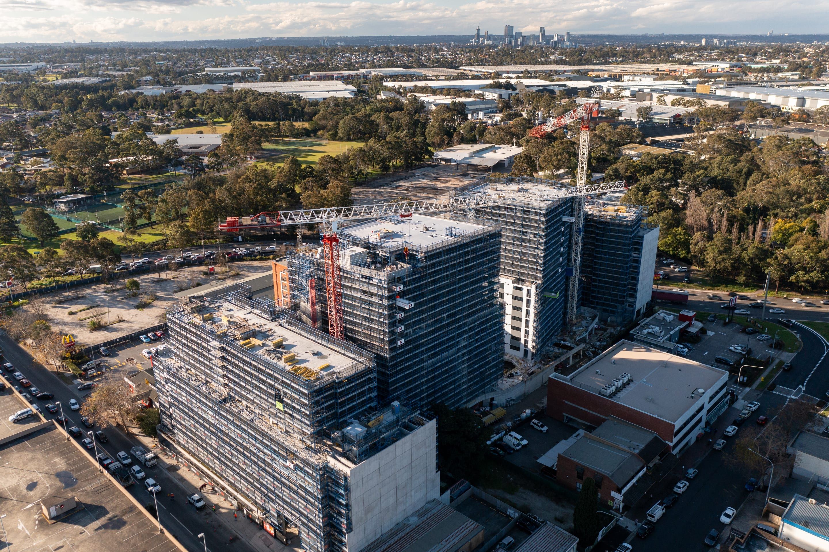 Scaffolded towers and tower cranes over Fairfield, the suburbs and a distant skyline beyond